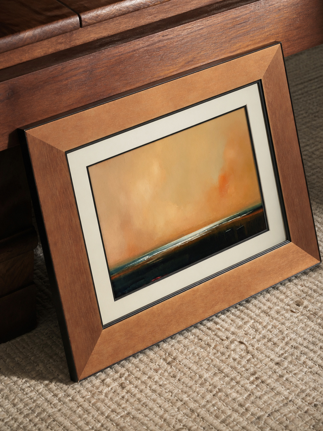 MOOJI ART warm amber landscape framed wall art angled on a woven rug with warm brown solid-wood frame
