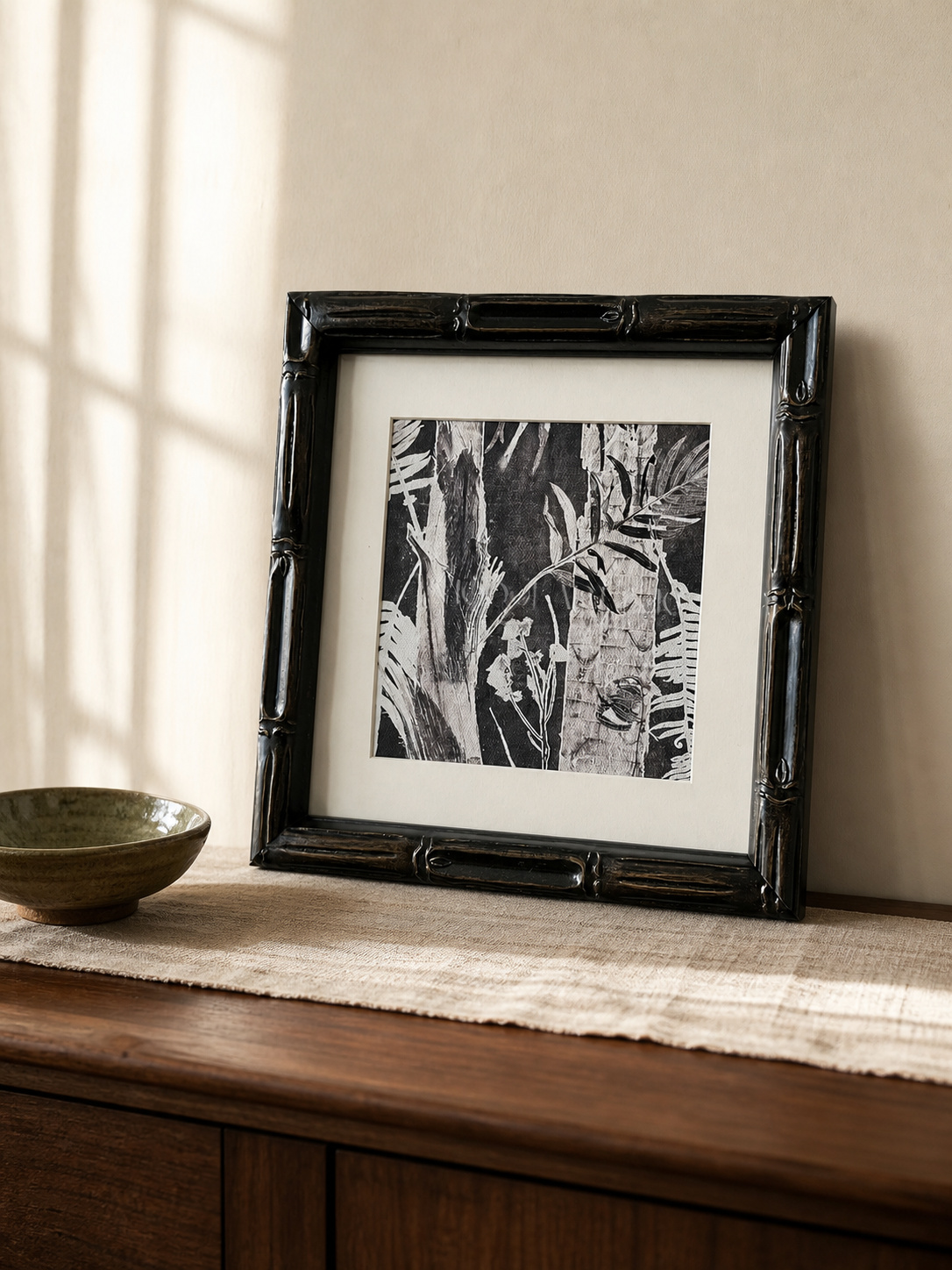 MOOJI ART monochrome botanical foliage framed wall art leaning on a walnut sideboard